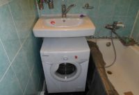 Pračka Kandy pod umyvadlem, vpravo vana